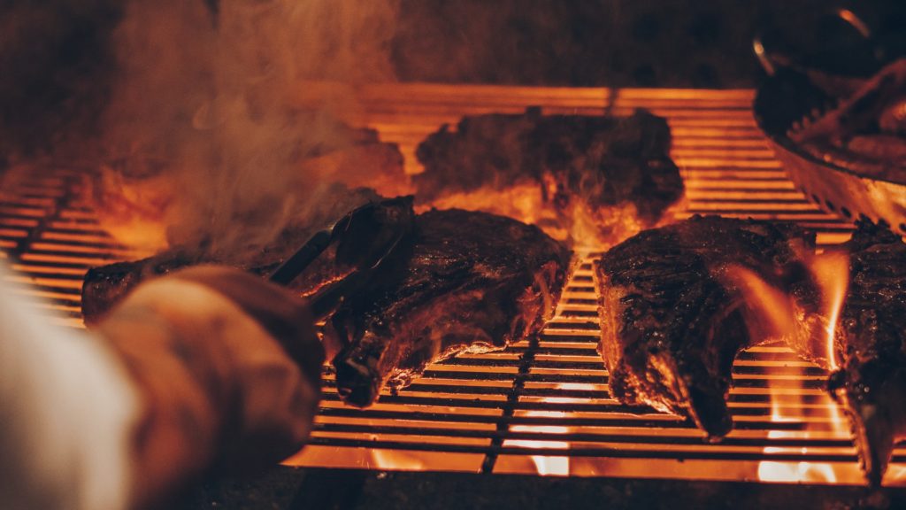 barbecuing meat with smoke and fire