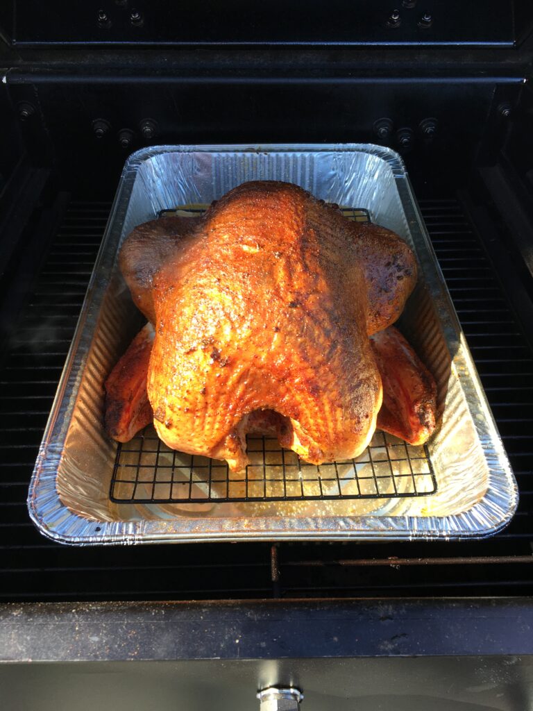 Golden-brown smoked turkey, fully cooked and ready to carve, featured in this smoked turkey recipe.